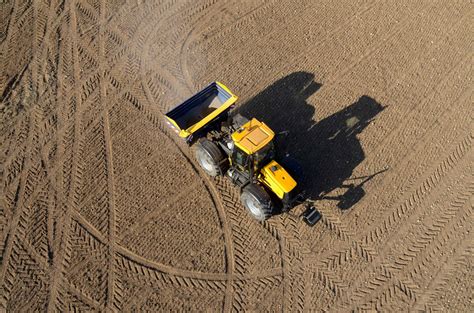 Tematické foto: Traktor zaorávajúci slamu do pôdy na poli