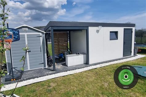 Detailný pohľad na záhradný domček G21 GAH 429 v exteriéri s uskladneným záhradným náradím a kosačkou