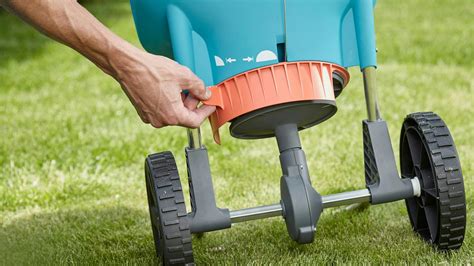 Záhradník aplikuje hnojivo pomocou fúrika.