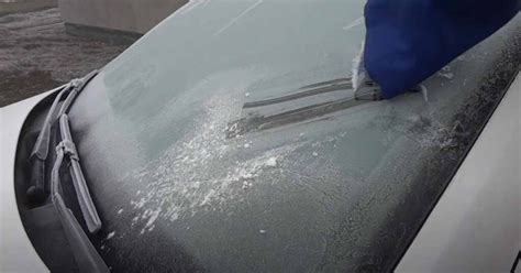 Zimné ráno a zamrznuté čelné sklo automobilu