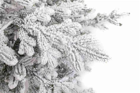 Detailný záber na zasnežené ihličie vianočného stromčeka s realistickým efektom snehu