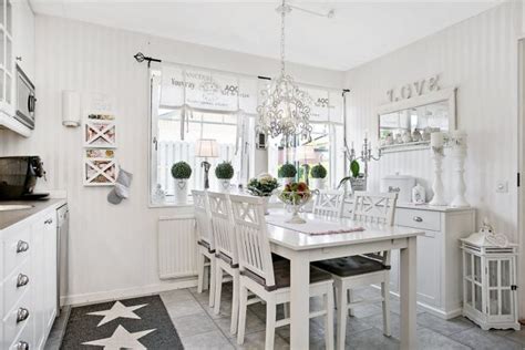 Interiér romantického záhradného domčeka zariadený v štýle shabby chic s bielym nábytkom