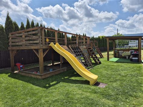 Ilustračná fotografia detského dreveného domčeka s terasou a prvkami ihriska v záhrade