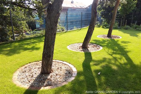 ukážka záhrady s tmavohnedým okrasným štrkom okolo stromov a na chodníkoch