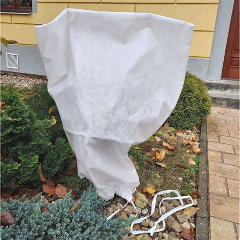 Detailné zobrazenie správneho upevnenia netkanej textílie pomocou úchytov a kameňov.