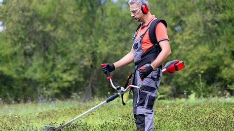 Tematické foto: človek používajúci AKU strunovú kosačku v záhrade
