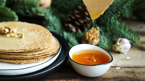 Ilustrácia tradičnej slovenskej vianočnej večere s oblátkami, medom a cesnakom.