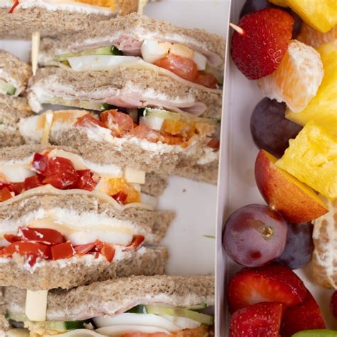 Rôzne druhy piknikových jedál: sendviče, šaláty v pohároch, ovocné špízy.