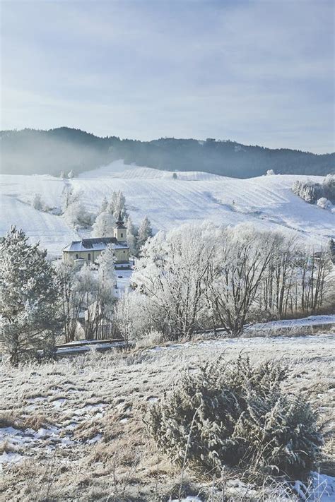 Tematická fotografia: Chata v zimnej krajine zasnežených hôr s lyžiarmi v pozadí