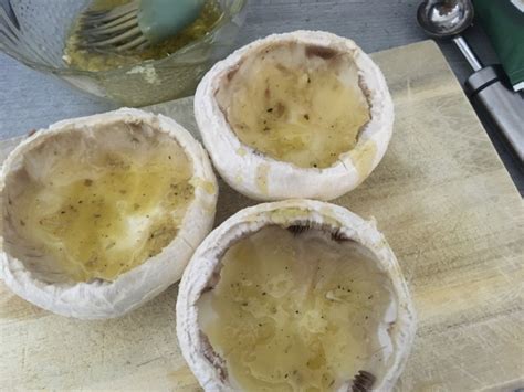 Detailný záber na naplnené hlavičky šampiňónov pripravené na pečenie