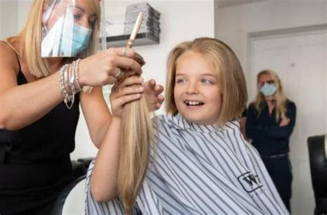 Dieťa pri prvom strihaní vlasov u kaderníka s rodičom