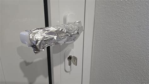 Detailný pohľad na ventilačnú mriežku a zámkovú petlicu na dverách