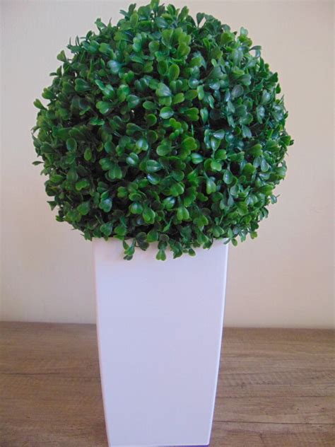 Umelý krušpán v tvare gule umiestnený v modernom kvetináči.