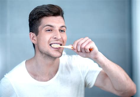 Tematické foto: človek si čistí zuby alebo zubná kefka s pastou