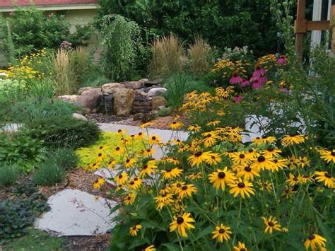 Príklad kompozície s tuou východnou 'Aurea Nana' v kombinácii s inými rastlinami a kameňmi
