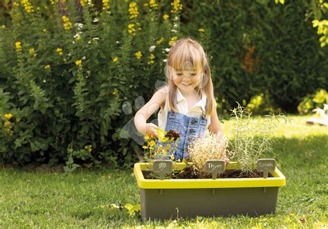 Deti hrajúce sa v záhradnom domčeku s doplnkami ako sú záclonky a kvetináč