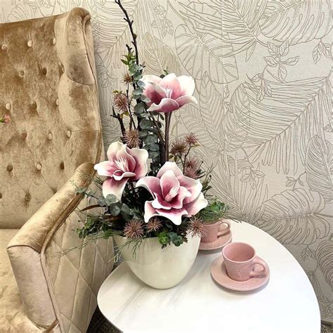 Aranžmán orchideí v sklenených vázach na konferenčnom stolíku.