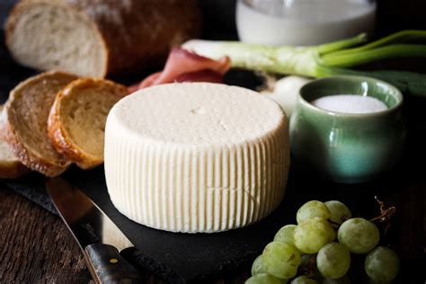 Tematické foto: čerstvý domáci syr na drevenej doske s bylinkami