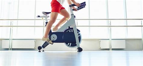 Osoba mierne cvičiaca na stacionárnom bicykli.