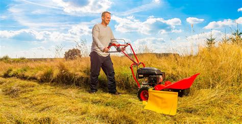 Tematické foto: bubnová kosačka v akcii kosí vysokú trávu na nerovnom teréne