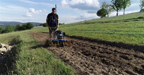 Malý akumulátorový rotačný kyprič v prevádzke na menšom záhone
