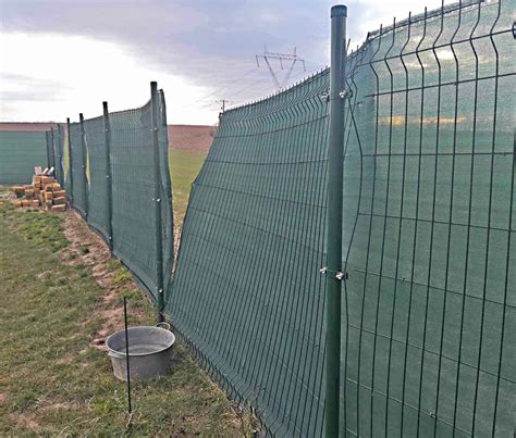 Fotografia zelenej tieniacej siete inštalovanej na drôtenom plote v záhrade