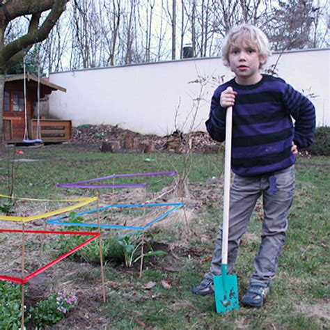 dieťa hrajúce sa s detskou kosačkou v záhrade