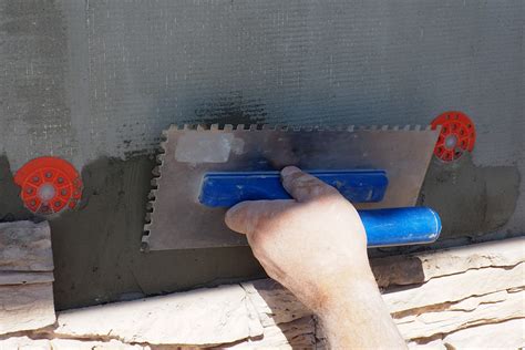 Ilustrácia techniky lepenia kameňa: nanášanie lepidla na podklad aj na rubovú stranu kameňa.