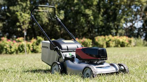 Detailný pohľad na modernú akumulátorovú kosačku Extol pri práci na udržiavanom trávniku