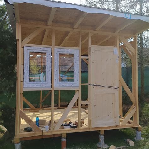 Detail detského dreveného domčeka s prvkami ako stolček a možnosťou pripojenia šmýkačky